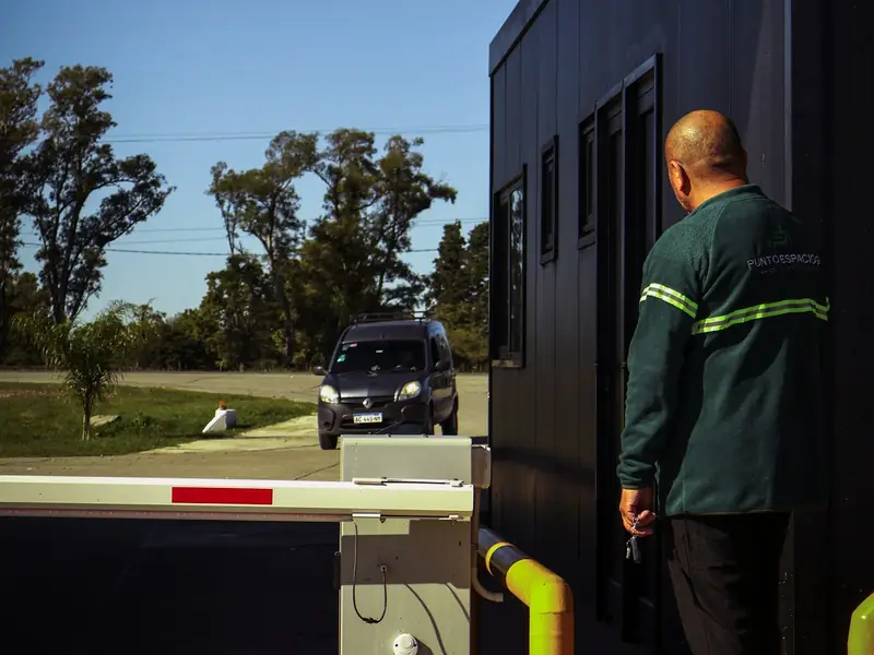 Garita de control de accesos con barrera vehicular y operario